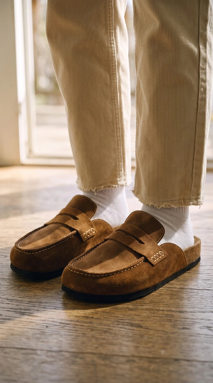 Mules Havana Tobacco portées avec un pantalon beige, dans une lumière naturelle